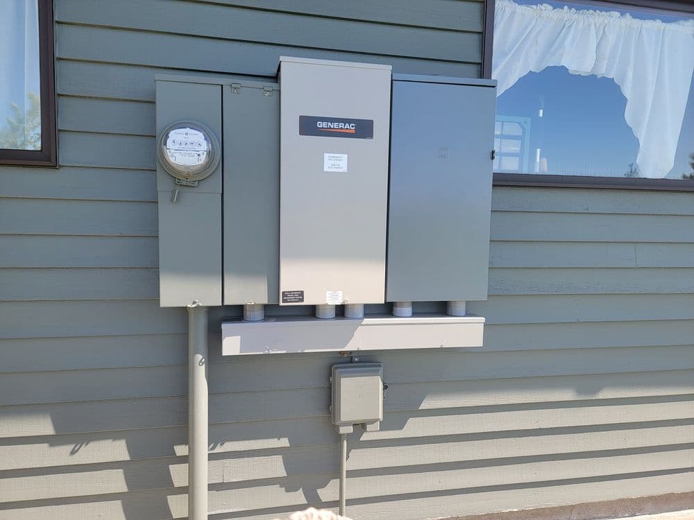 Generac generator installation with electrical meter on a house exterior wall.
