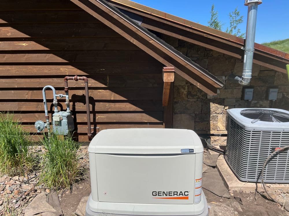Generac home backup generator near utility connections and air conditioning unit.