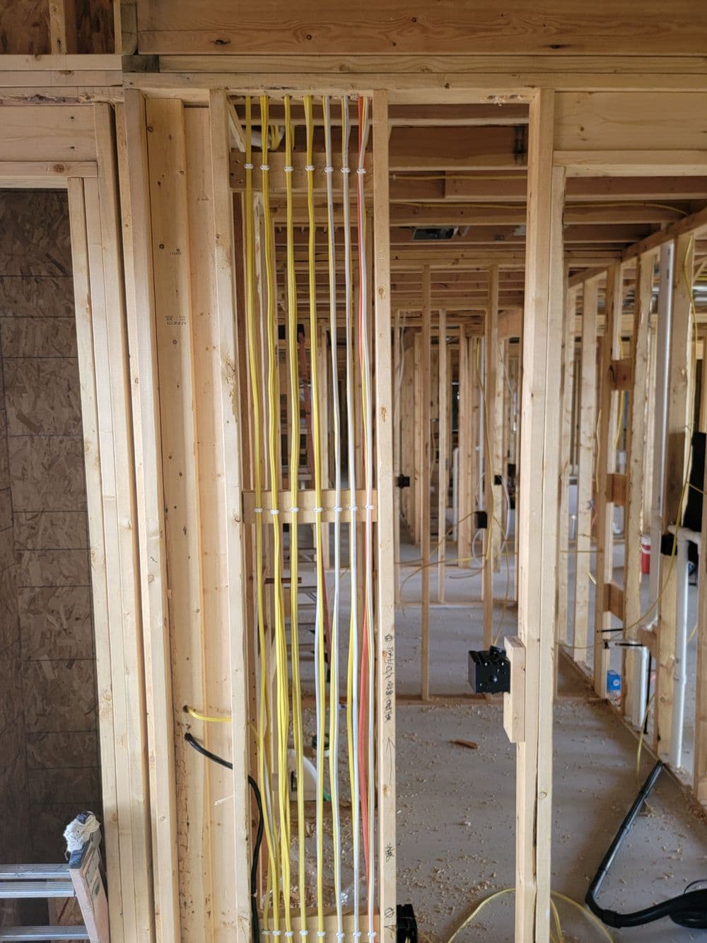 Electrical wiring installation in a new home construction frame showcasing organized cables.